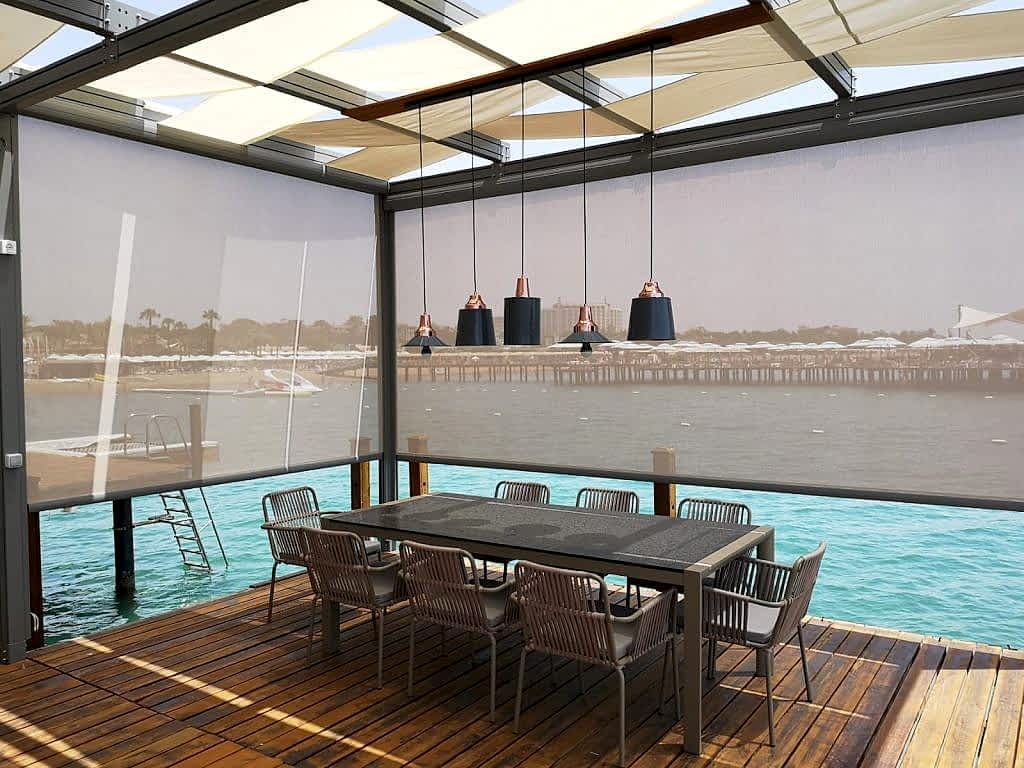 Zip perde sistemi ile kapatılmış modern kış bahçesi alanı